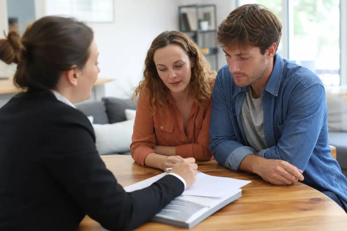 Couple signant des documents avec une conseillère